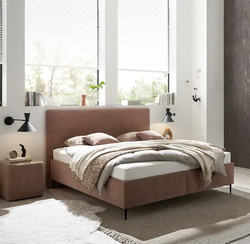 Helles Schlafzimmer mit modernem Polsterbett in Rosé, schlichten Beistelltischen und Wandlampen – gemütliches Schlafambiente, skandinavischer Wohnstil, komfortables Bett für modernes Schlafzimmerdesign.